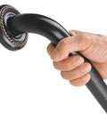 Close-up of a hand gripping the Heavy Duty 12 Inch Textured Grab Bar For Bathtub And Shower With Oil Rubbed Bronze Finish.