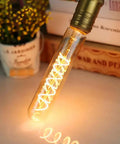 Cozy Amber Glow T10 LED Filament Bulbs 2200K warm white tubular Edison style bulb illuminating on desk