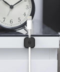 Magnetic Cable Clips 3 Pack For Car And Office Cable Management Self Adhesive Cable Organizer Clips holding white cable on desk
