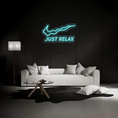 Just Relax LED Neon Light Sign For Wall Decor USB Powered With Switch Bright Neon Lights above a white couch in a dark room.