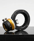 Off Axis Guider With Tilt Adjuster OAG Pro for astrophotography, black and gold, on a reflective surface.
