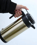 Person holding the Road Ready Dope Portable Water Heater For Car And Truck 12V 24V, showing stainless steel design.