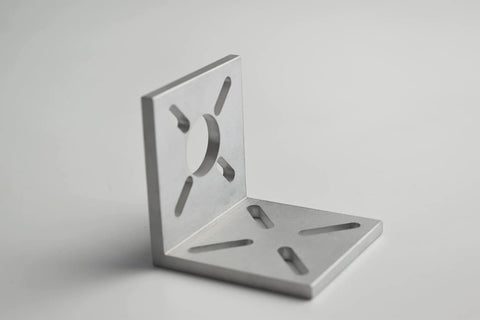 Aluminum L-shaped motor mounting bracket with central circular hole and elongated slots, angled front view