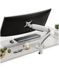 Rock Solid Single Monitor Desk Mount With Smooth Floating Arm Fits Up To 32 Inch Screens installed on a white desk with accessories.