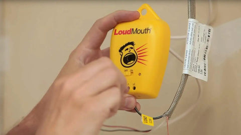 Hand holding LoudMouth Monitor Fault Detector for Indoor Electric Heating Tape Mats and Underfloor Heating Installations, Yellow Unit.