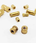 25 Pack Solid Brass Knurl Insert Nuts M2 M2.5 M3 Metric Threads Round Shape OD Options For Heavy Duty Projects And Tight Fits scattered on a white background.