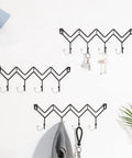 Black Wrought Iron Wall Mount Coat Hooks With Smooth Polish Heavy Duty Key Hangers Vibe Up Your Living Room Or Bedroom Setup on a white wall.