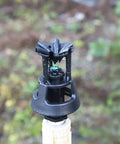 Close-up of rotary oscillating irrigation sprinkler nozzle for farm crops adjustable spray radius 6 to 9 meters low pressure.
