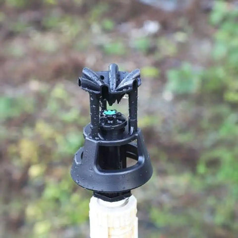 Close-up of rotary oscillating irrigation sprinkler nozzle for farm crops adjustable spray radius 6 to 9 meters low pressure.