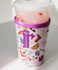 Premium Neoprene Iced Coffee Sleeve Keeps Your Daily Grind Crisp And Chill With Tough Fabric Coated Material And Reinforced Seams Built For Medium Cups Spanning Twenty Two To Twenty Eight Ounces Of Your Favorite Sip with pink design on medium cup.