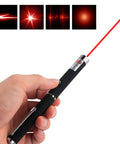 Hand holding a laser pointer emitting a red beam, part of a Three Pack Laser Pointer For Cats And Dogs Interactive Pet Toy Set With Red Green And Purple Lights Great For Playtime And Training Requires Two AAA Batteries Not Included.