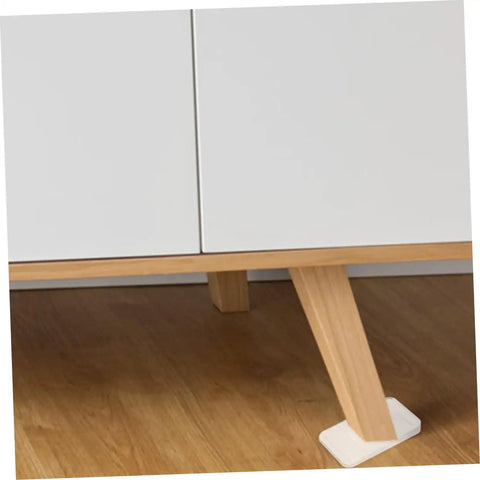Clear Plastic Leveling Shims For Furniture Wobble Fix 32 Piece Wedge Set under a table leg on hardwood flooring.