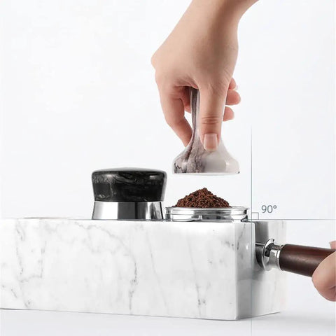 Top Shelf Marble Espresso Tamper Holder Stand Fits 51mm And 54mm Coffee Tools in use with coffee grounds on a kitchen counter.