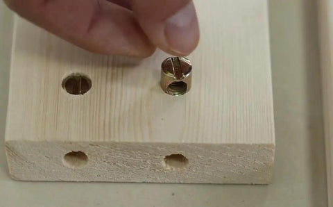 Person inserting barrel nut into wood for Hella Sturdy M6x100mm Bunk Bed Bolts Compatible With Ikea Bed Frames.