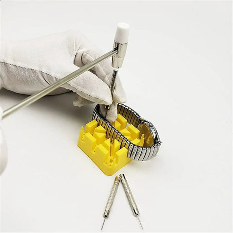 Gloved hand using 147Pcs Watch Repair Tool Kit With Portable Case For Band Link Removal And Watch Maintenance Professional Grade Precision Screwdrivers Pin Pushers Spring Bar Tools And Jewelry Tweezers For Home And On The Go on yellow block