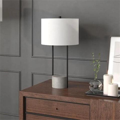 65.5 Inch Tall Floor Lamp With White Drum Shade In Blackened Bronze And Concrete Finish next to candles and decor