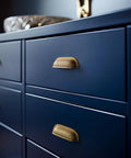 Six Pack 3 Inch Antique Brass Cabinet Cup Pulls With Hand Hammered Texture And Smooth Curved Edges on blue drawers