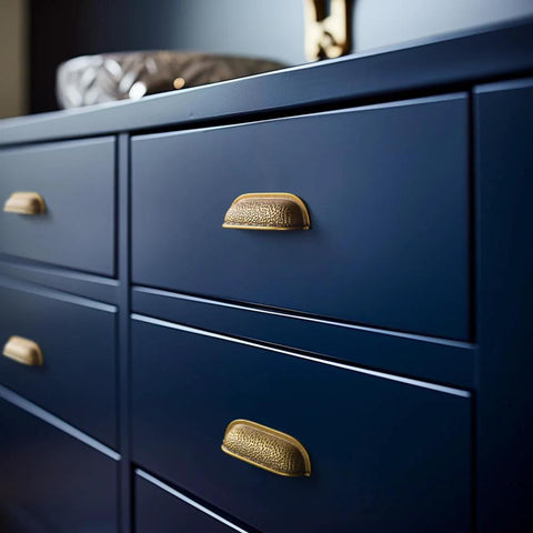 Six Pack 3 Inch Antique Brass Cabinet Cup Pulls With Hand Hammered Texture And Smooth Curved Edges on blue drawers