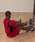 Man using Pro-Grip Multi Bar Cable Attachment with Rubber Grips for seated rows on a cable machine in a gym.