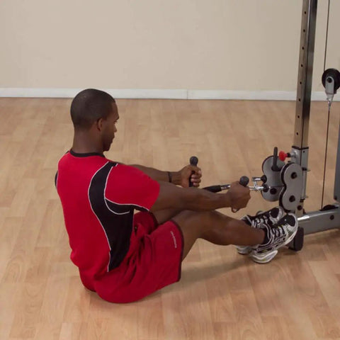 Man using Pro-Grip Multi Bar Cable Attachment with Rubber Grips for seated rows on a cable machine in a gym.