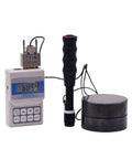 Premium Kickass Digital Hardness Tester With Analog Dial Gauge For Serious Industrial And Shop Floor Testing Metal Rubber Plastic Composites Includes Hard Shell Case And Calibration Block Lightweight Easy One Hand Hold displayed with calibration block.