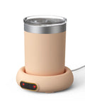 Keep Your Sip Fire All Day Long With This Game Changing Electric Mug Warmer Featuring Smart Gravity Switch And Smooth Metal Plates For Even Warmth Ideal For Busy Offices Or Laid Back Weekend Hangouts. Image of a peach-colored electric mug warmer with a glass mug.