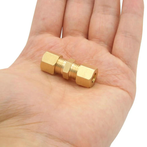 Hand holding brass compression fittings ice maker connector