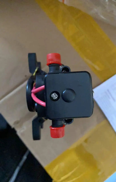 Top view of a 12V water pressure diaphragm pump with red connectors, suitable for RV, boat, caravan marine use, 35 PSI.
