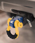 Beefed-Up Heavy Duty Three Quarters Inch D Ring Shackles Set Forged Steel Tow And Winch Shackles Four Point Seven Five Ton Load Capacity Two Pack Off Road Recovery Gear Yellow Powder Coat With Isolators attached to vehicle hitch