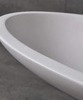 Close-up of the edge of a Top Shelf White Oval Vessel Vanity Sink Solid Artificial Stone Above Counter Bowl Basin.