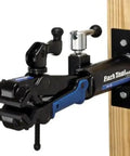 Pro Grade Wall Mount Bike Stand With Heavy Duty Clamp And Locking System, attached to a wooden post, powder coated blue finish.
