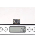 ExpressLRS RX24T 2.4G Nano Receiver on digital scale, weighing 0.6g, for DIY racing drones, long range ELRS radio FPV.