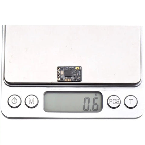 ExpressLRS RX24T 2.4G Nano Receiver on digital scale, weighing 0.6g, for DIY racing drones, long range ELRS radio FPV.