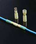 Rock-solid 100 Piece Electrical Spade Wire Connector Kit Featuring Durable Heat Shrink Male And Female Tips For All Your Wiring Jobs With Super Secure Grip. Male and female heat shrink spade connectors on blue wire.