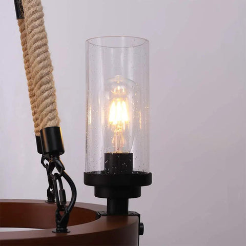 Close-up of wood frame and seeded glass shade on Farmhouse Wagon Wheel Ceiling Chandelier with lit bulb and rope detail.