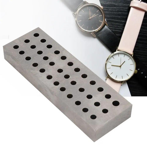 Heavy Duty Watch Staking Tool With Metal Plate 36 Holes Riveting Stake Set next to watches on desk