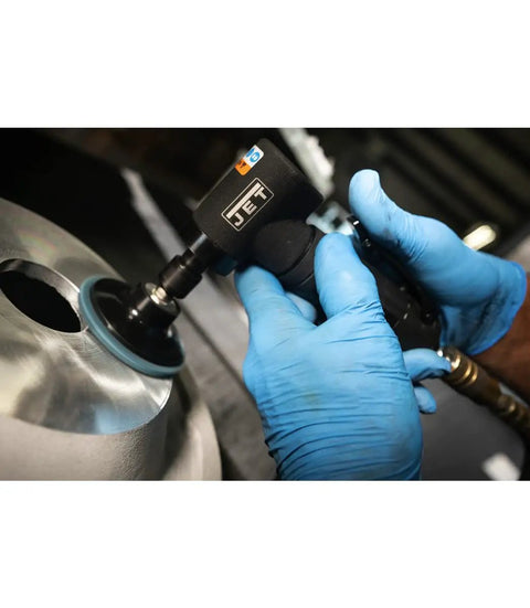 User operating the Badass Quarter Inch Pneumatic Angled Die Grinder Spins 20000 RPM on a metal surface with blue gloves.