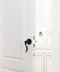 Quiet Operation Matte Black Door Lever Handle with Silent Technology and Wave Style Privacy Lock on a white interior door