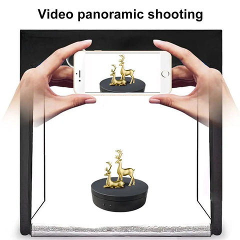 Person photographing a golden deer sculpture on the Emvanv Electric Rotating Display Turntable 360 Auto Spin Platform.