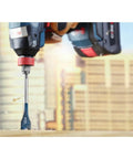 Bosch DSB1013 Daredevil spade bit, 1 in x 6 in, in drill chuck drilling into wood.