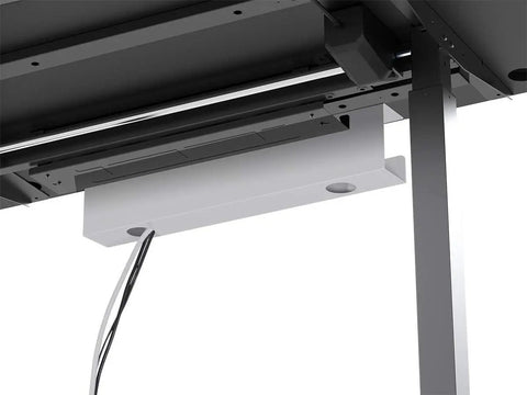 White under desk cable tray with steel wire management installed beneath a desk for organizing power strips and adapters.