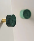 Six Pack 30mm Green Marble Cabinet Knobs With Brushed Brass Base mounted on a sleek surface, showcasing round natural stone design.