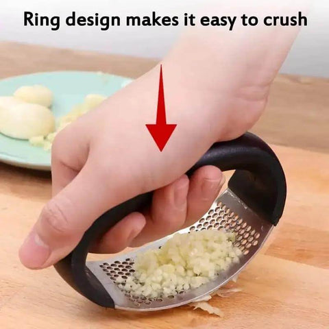 Hand using Stainless Steel Garlic Press Rocker Mincer With Peeler on cutting board to crush garlic effortlessly