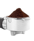 Electric Milk Frother For Cappuccino And Latte Brewing Stainless Steel Coffee Steamer with coffee grounds in a metallic portafilter.