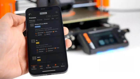 Person holding a smartphone showing the MK4S 3D Printer Kit With Automatic Calibration And Removable Sheets interface screen.