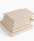 Stack of hard wearing PEEK plate material engineering plastic sheets, sizes 50x50mm or 50x100mm, 3mm to 20mm thick, for prototyping and machining.