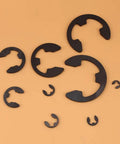 300 Piece E Clips Assortment Kit In Black Metal For Shafts And Housings Durable Retaining Rings Set 3mm To 22mm displayed on orange background