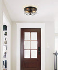 Industrial Black 13 Inch Flush Mount Ceiling Light With Seeded Glass Shade And Metal Cage in entryway.