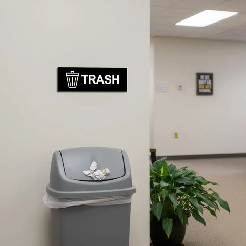 Basic Trash Sign Brushed Silver Small For Walls Or Doors, Durable Plastic With Clear Text, installed above trash can in office