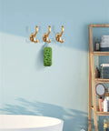 Rock Solid Heavy Duty Wall Mounted Coat Hook For Doors And Walls with three gold hooks holding a green sponge.